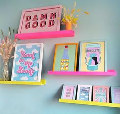 three colorful shelves with pictures on them and flowers in vases next to each other