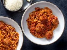 two bowls filled with spaghetti and meatballs next to a bowl of grated rice