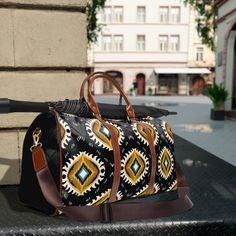 a black and yellow duffel bag sitting on top of a metal table next to a building