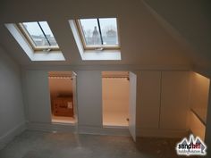 an empty room with two skylights on the ceiling