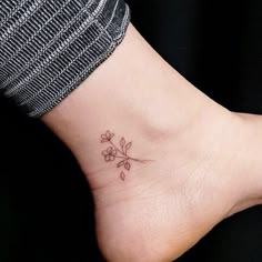 a small flower tattoo on the ankle