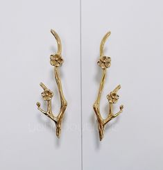 two golden metal hooks with flowers on them