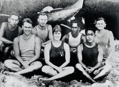 a group of men and women sitting in front of a boat