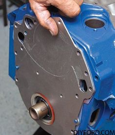 a person is working on a machine with their hand over the top of one of the gears