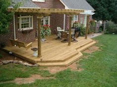 a wooden deck in front of a brick house