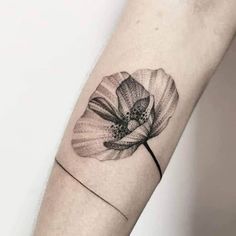 a single flower tattoo on the left forearm and arm, it is black and white