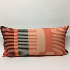 an orange and black striped pillow on a white background