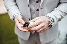 a man in a suit is holding his cell phone