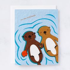 two brown bears standing next to each other on top of a blue card with water