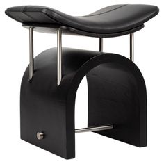 a black chair with a metal frame and foot rest on it's back end