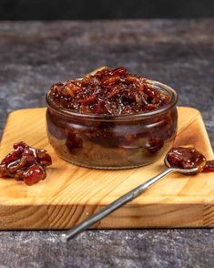 a wooden cutting board topped with raisins next to a bowl of raisins