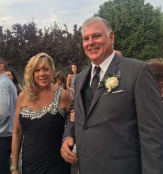 a man and woman in formal wear standing next to each other at an outdoor event