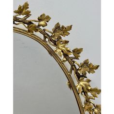 a mirror that has some gold leaves on it