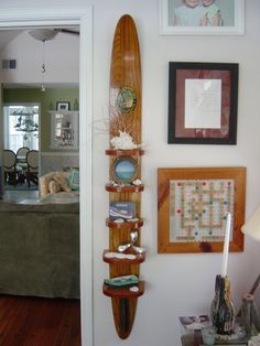 a surfboard mounted to the side of a wall in a room with pictures on it