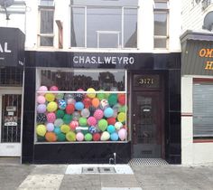 there is a store front with balloons in the window