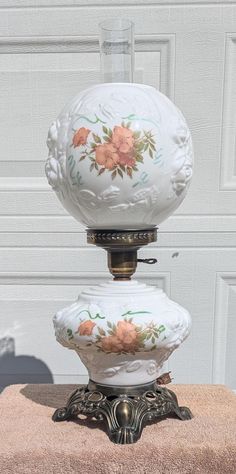 an old fashioned lamp is sitting on top of a towel in front of a white door