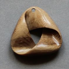 a wooden object that looks like an ornament on the ground with a hole in it