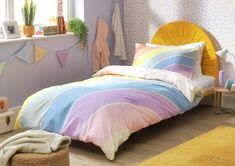 a bed room with a neatly made bed next to a window and rugs on the floor