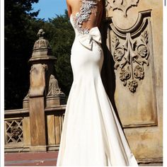 a woman in a wedding dress leaning against a wall