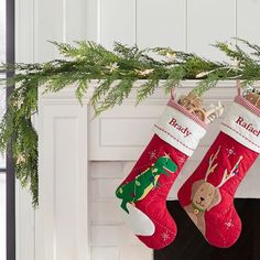 two christmas stockings hanging from a mantel