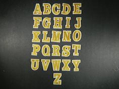 the letters and numbers are made out of yellow thread on a black surface with white writing