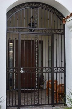 an iron gate is open on the outside of a house