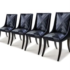 four black leather dining chairs with diamond patterned upholstered backrests and tapered legs