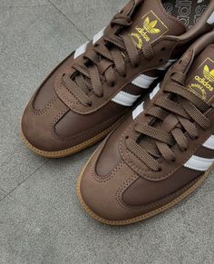 Der adidas Samba OG 'Earth Strata Gum' bringt den klassischen Samba-Look mit erdigen Tönen und zeitlosen Details auf den neuesten Stand. Das Obermaterial aus hochwertigem Leder in einem satten Braunton namens "Earth Strata" wird durch cremeweiße Akzente an den drei Streifen und der Ferse ergänzt. Die Gummisohle bleibt dem typischen Samba-Stil treu und verleiht dem Sneaker einen unverkennbaren Retro-Look. Dank der neutralen, aber edlen Farbgebung lässt sich dieser Schuh sowohl lässig als auch elegant kombinieren und ist eine vielseitige Ergänzung für jede Garderobe. SKU: IE6522 Colorway: Earth Strata/Cremeweiß/Gum Fall Adidas, Aesthetic Youtube, Dream Shoe, White Pizza, New York Outfits, Ootd Women, Crochet Aesthetic, Adidas Samba Og, Fashion Crochet