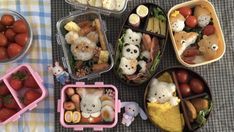 several plastic containers filled with food on top of a checkered table cloth next to strawberries