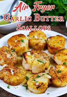 garlic butter scallops on a white plate with parsley