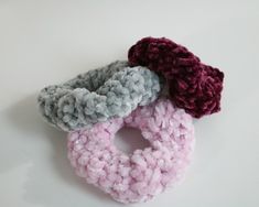 three crocheted donuts sitting on top of a white table next to each other