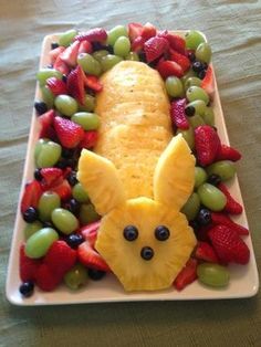 a white plate topped with fruit and an animal shaped in the shape of a face