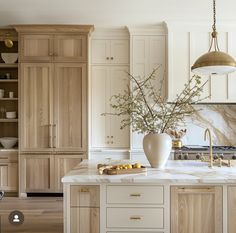 a large kitchen with marble counter tops and wooden cabinetry, along with an island in the middle