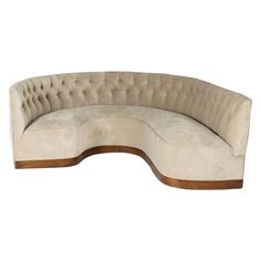 an oval shaped couch with wooden legs and a beige upholstered fabric cover on the back