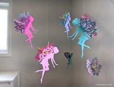 paper cut fairy mobiles hanging from strings in the shape of tinkerbells