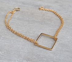 A delicate gold square bracelet, 14k goldfilled chain doubles on each side of a 14k goldfilled square pendant. This is your perfect gold jewelry for everyday wear. The bracelet measures 7 inches. The 14K gold filled square pendant measures 0.6 inch / 1.5 cm. Please take a minute to check out my other modern bracelets: http://www.etsy.com/shop/HLcollection?section_id=12318419 All jewelry ships individually gift wrapped in a box with a bow. perfect for giving or treating yourself! ♥ ♥ ♥ ♥ ♥ ♥ ♥ ♥ Adjustable Gold Cube Jewelry, Adjustable Yellow Gold Rectangular Chain Bracelet, Adjustable Square Gold Bracelet, Dainty Gold Square Jewelry, Square Gold Minimalist Jewelry, Minimalist Square Gold Jewelry, Gold Square Bracelets As Gift, Gold Square Bracelets For Gift, Dainty Gold Rectangular Chain Bracelet