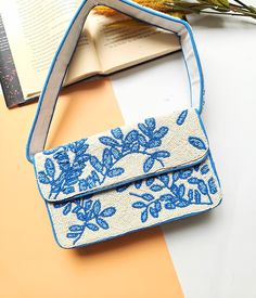 This handmade blue floral beaded shoulder bag features intricate blue embroidered flowers, making it a unique women's handbag and a nature-inspired accessory perfect for those seeking elegant blue shoulder bags. Add a touch of elegance to your wardrobe with this stunning handmade blue floral beaded shoulder bag, designed for those who appreciate fine craftsmanship and timeless style. Featuring intricate floral beadwork on a neutral white background, this bag is perfect for weddings, evening even Blue Rectangular Embellished Shoulder Bag, Blue Beaded Clutch Bag, Blue Beaded Clutch Evening Bag, Blue Beaded Evening Bag, Blue Embellished Rectangular Clutch, Rectangular Blue Beaded Clutch, Evening Blue Beaded Bag, Summer Blue Beaded Shoulder Bag, Blue Beaded Rectangular Bag