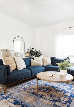 a living room with blue couches and rugs