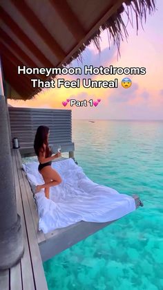 a woman sitting on top of a bed in the ocean next to a pier with text that reads honeymoon hotel rooms that feel unreall part 1