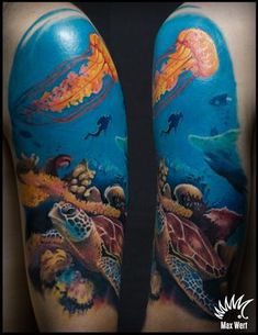 the back of a man's arm with an ocean scene and sea animals on it