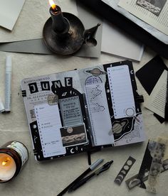 an open book sitting on top of a table next to a candle and other items