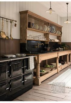 an old fashioned kitchen with wooden cabinets and black stove top oven, white rug on the floor