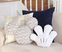 three decorative pillows sitting on top of a couch next to a stair case in a home