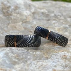 Gorgeous Matching Damascus Ring Set. The Men's Ring is 8mm wide with a 1 millimeter vertical 14k rose gold inlay and the women's ring is 6mm wide with a 1 millimeter 14k rose gold inlay. Our rings are made by the best jewelry artisans that the industry has to offer, and each ring is finished by hand. These rings have a comfort fit inside to ensure that the ring will rest comfortably on your finger throughout the day. Let us make you a ring that is unique to your style, something you can cherish Black Etched Rings For Anniversary, Anniversary Black Etched Rings, Matching Ring Set, Damascus Ring, Damascus Steel Ring, Mens Ring Sizes, Matching Ring, Titanium Rings, Matching Rings