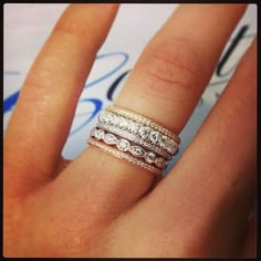 a woman's hand with three different rings on her finger and the ring has diamonds in it