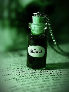 a bottle that is sitting on top of a book with the word blood in it