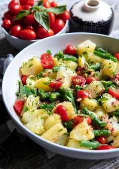 a bowl filled with potatoes, green beans and tomatoes