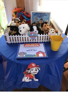 there are stuffed animals and books on the blue tablecloths at this children's birthday party