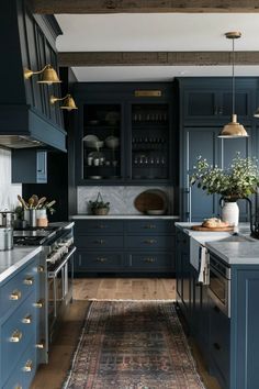 a kitchen with blue cabinets and an area rug on the floor in front of it