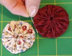 two pieces of fabric being sewn together on a green cutting board with scissors and thread